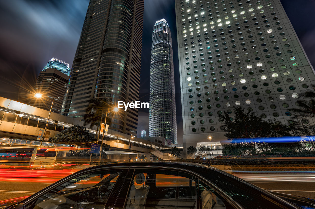 Car on street against two international finance center at night