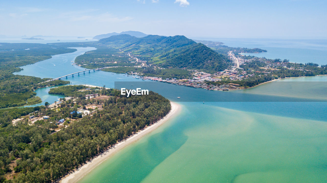 Aerial view of townscape by sea against sky