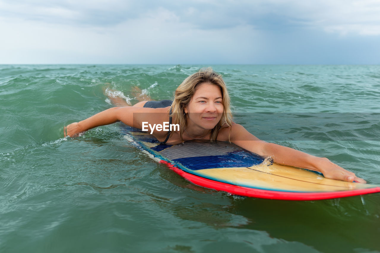 Man swimming in sea against sky