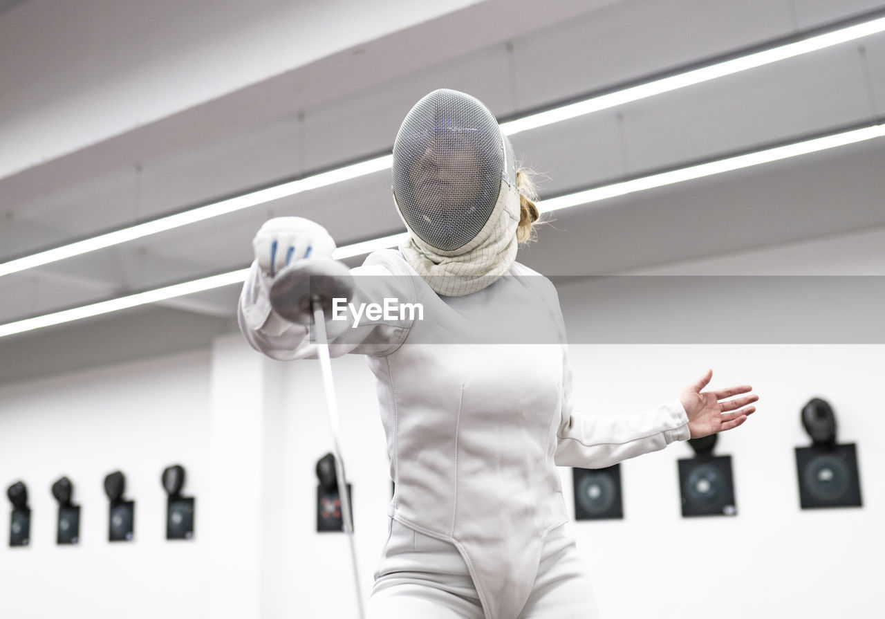 Woman in fencing outfit at gym