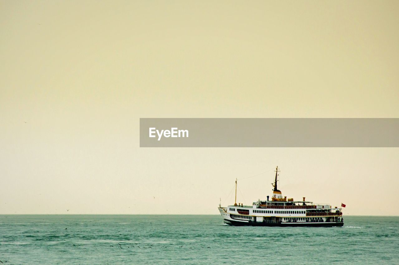 Lone boat in calm sea against clear sky