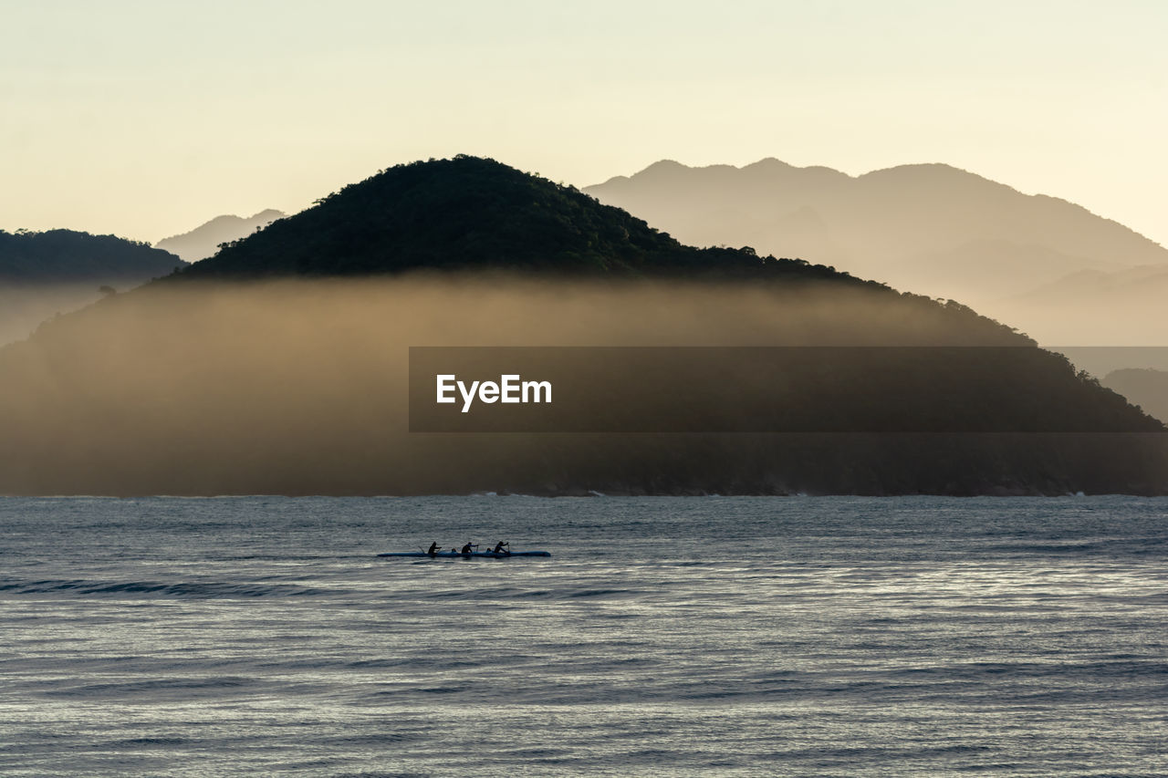 Scenic view of sea and mountains against sky