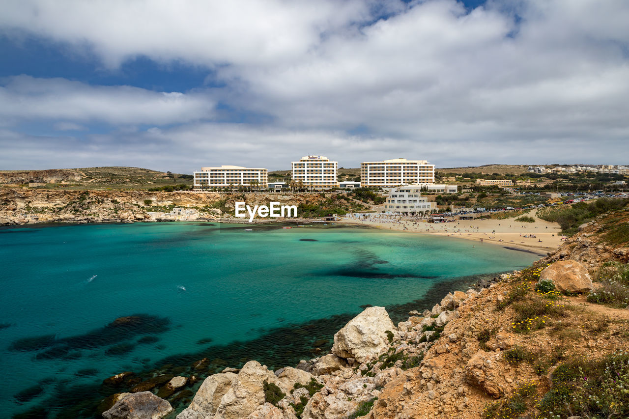 Scenic view of sea and buildings against sky