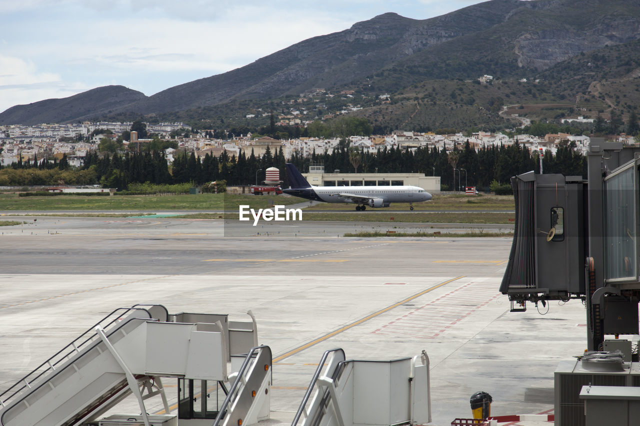 Airplane on runway against mountains