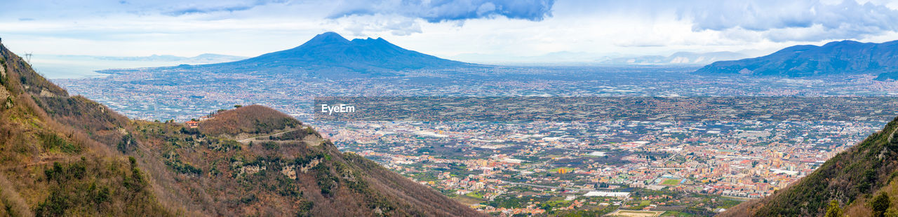 Panoramic view of city and mountains against sky