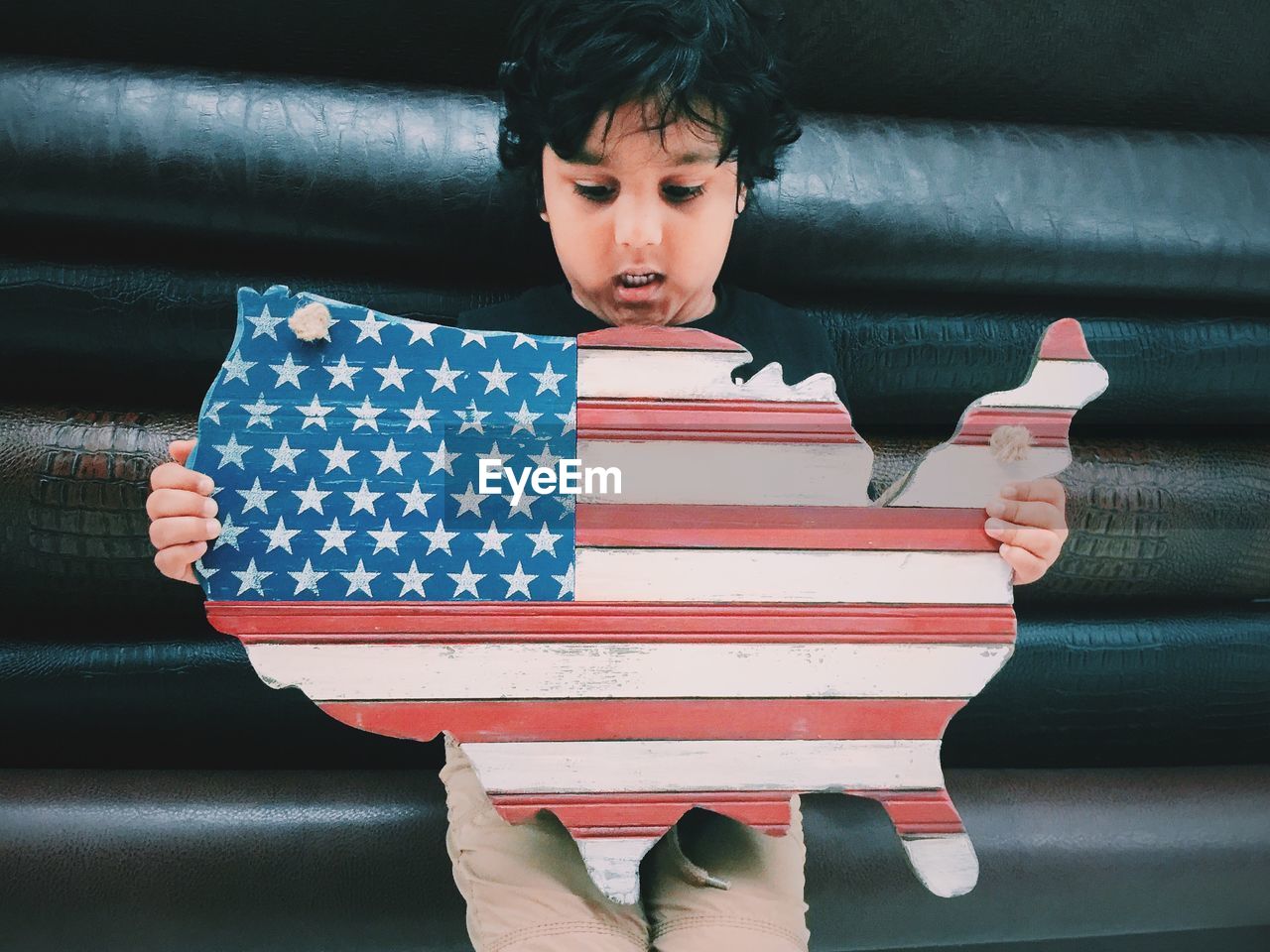 Boy holding american flag map