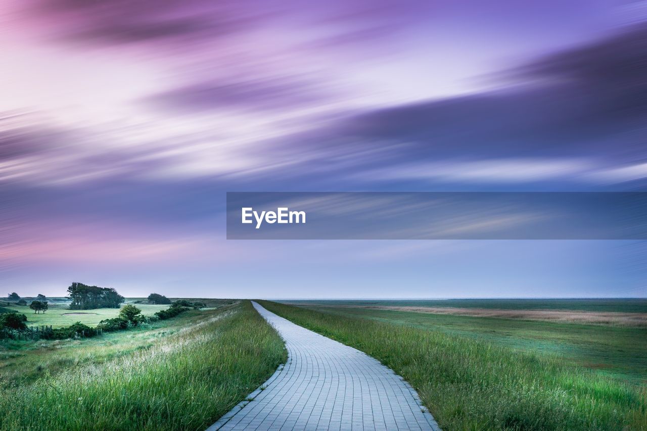 Scenic view of agricultural field against dramatic sky