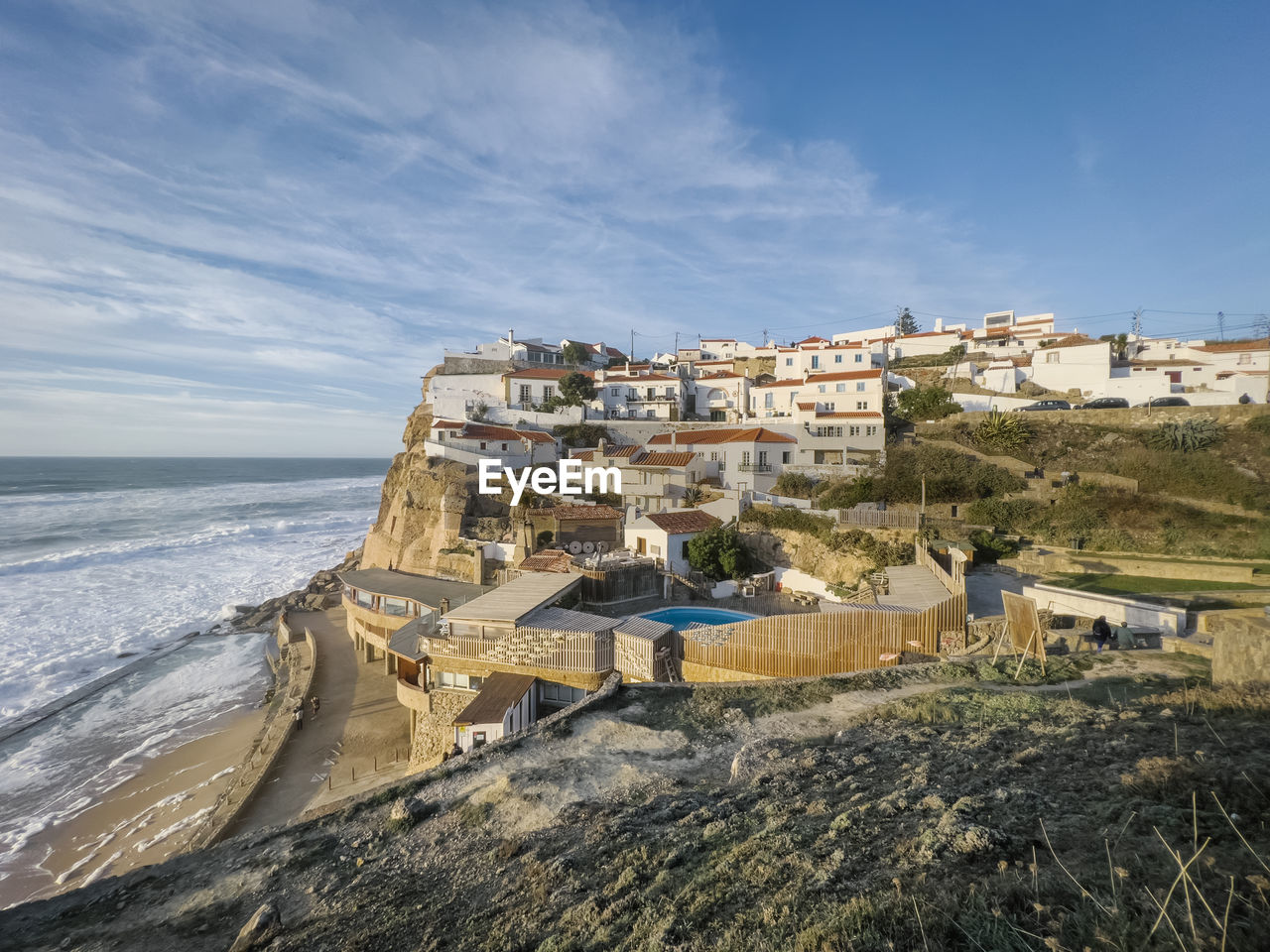 high angle view of townscape by sea against sky