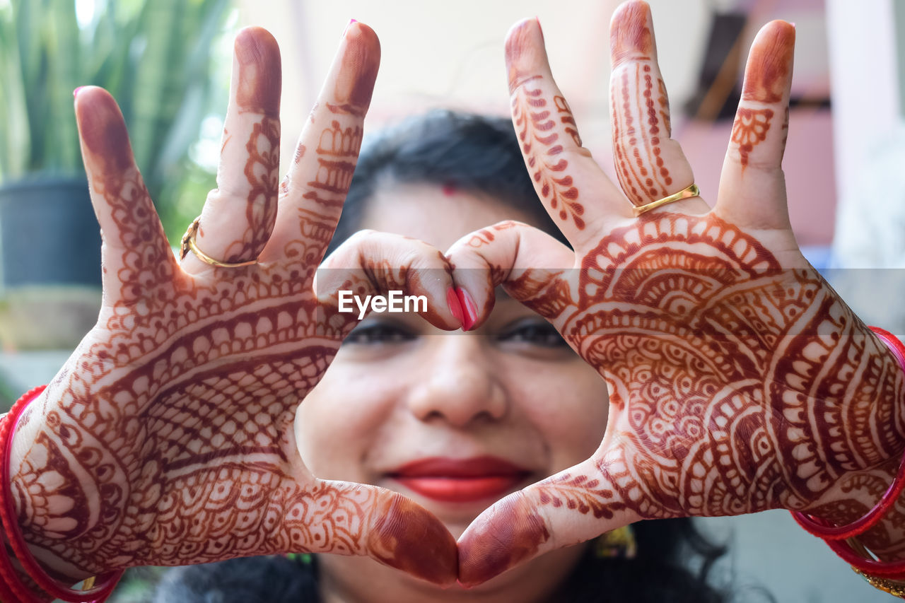 Beautiful woman dressed up as indian tradition with henna mehndi design on her both hands