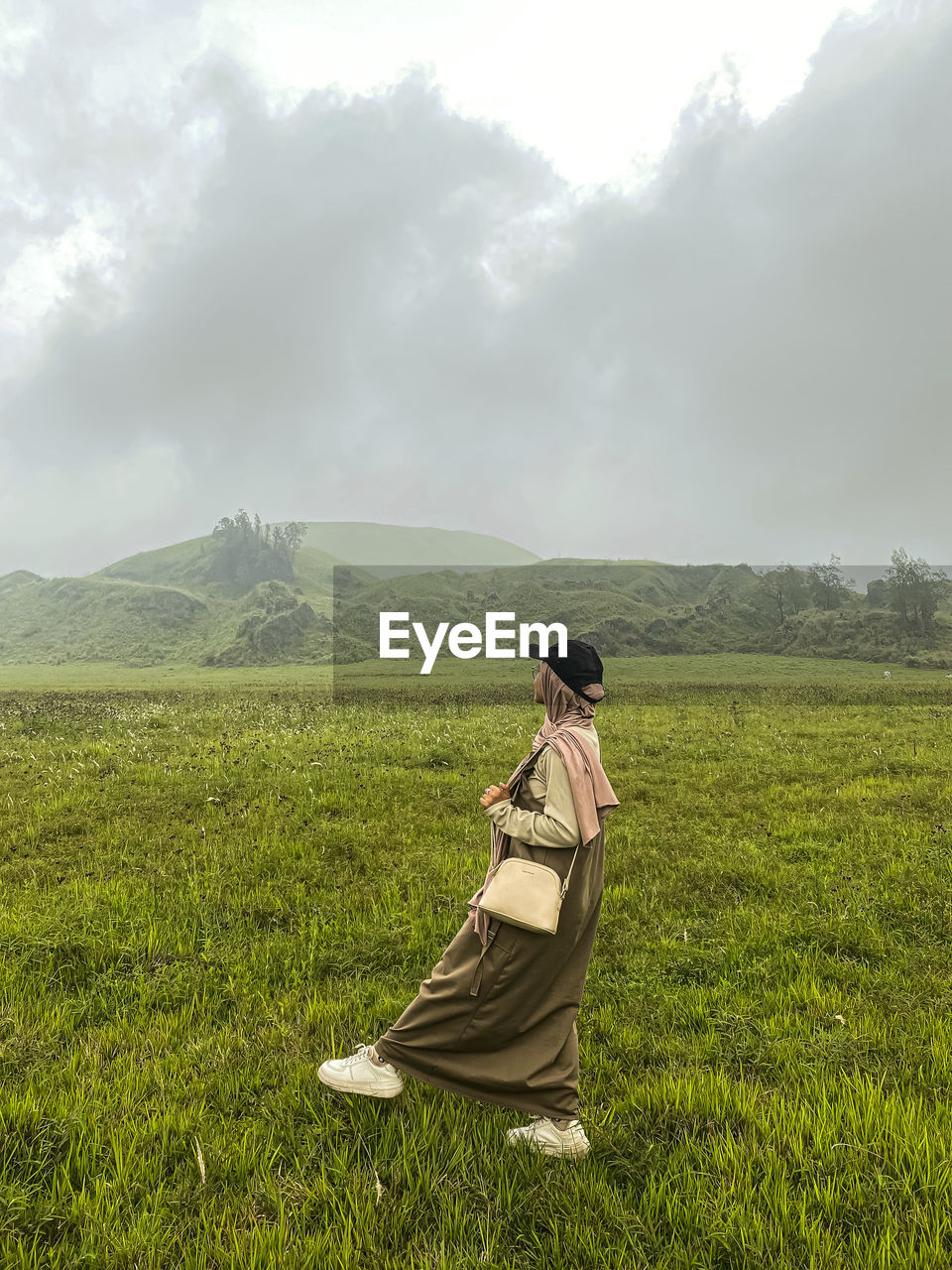 rear view of woman standing on grassy field