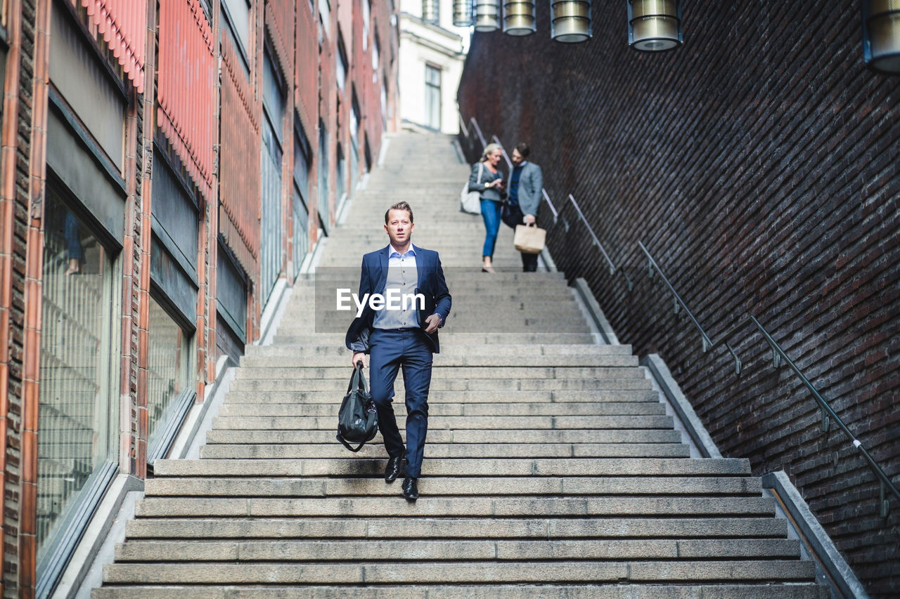 Portrait of mature businessman climbing steps