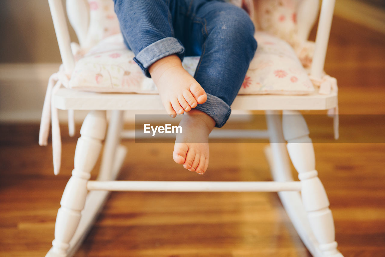 Low section of child sitting on chair