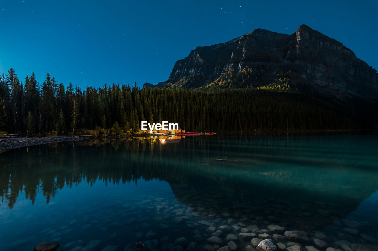 Scenic view of lake against clear sky at night