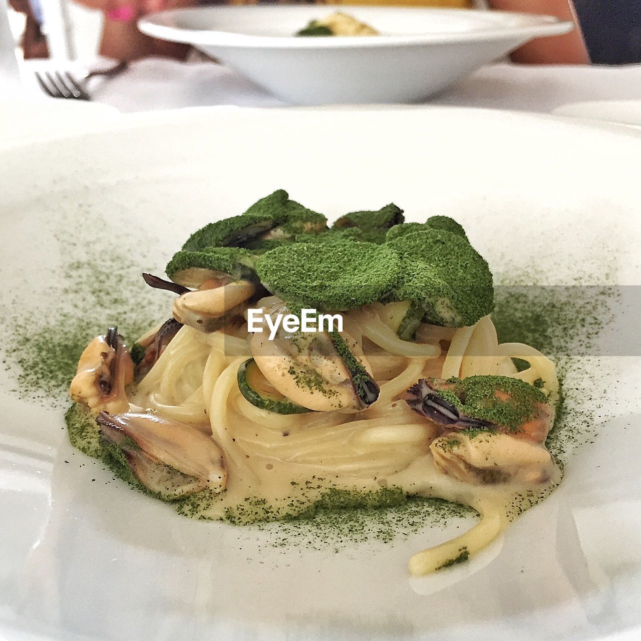 Close-up of noodles with pepper and spinach powder served in plate