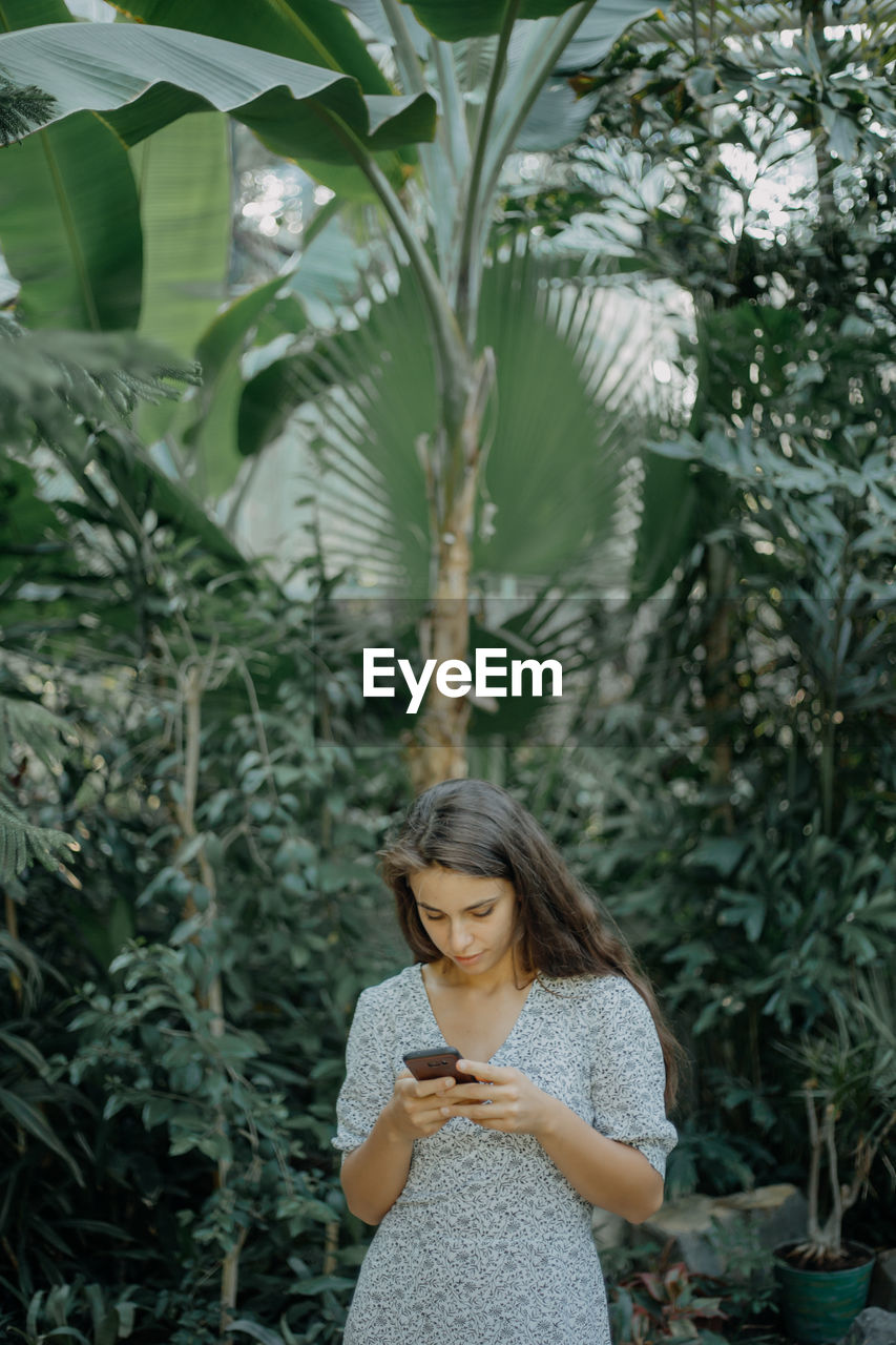 Woman standing against plants