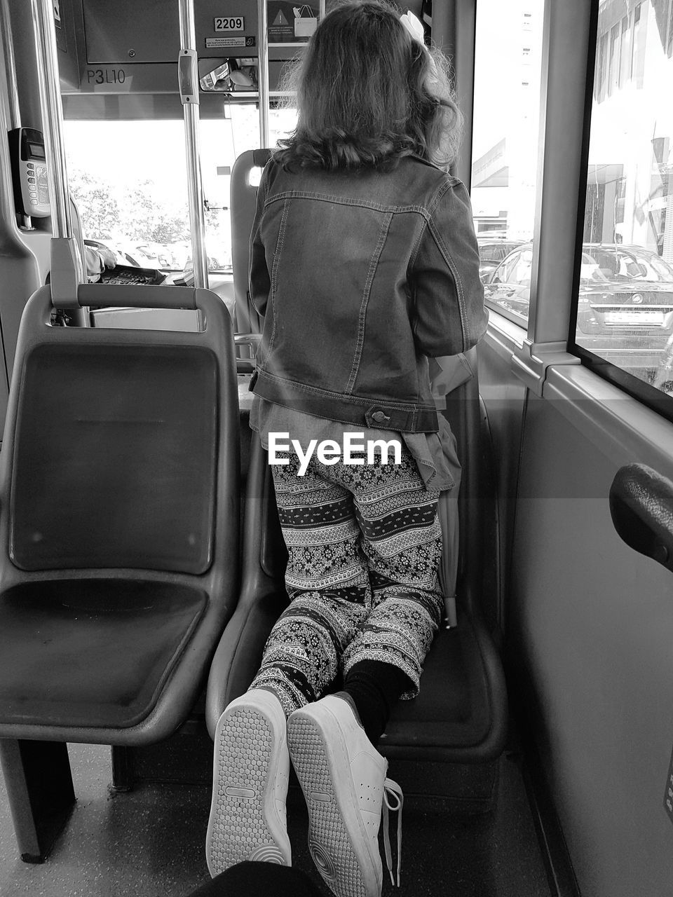 REAR VIEW OF MAN SITTING IN BUS