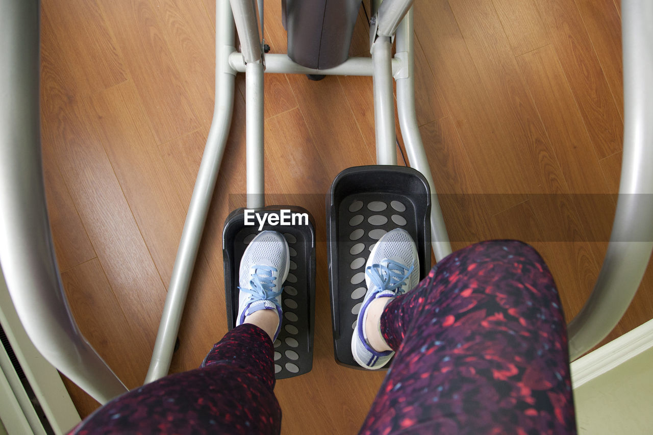 LOW SECTION OF WOMAN WEARING SHOES ON FLOOR