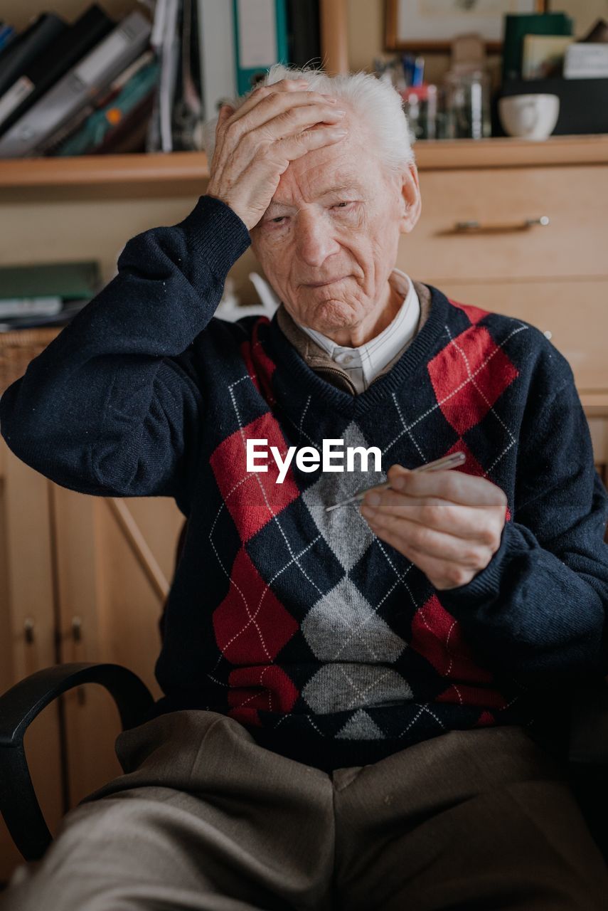 Midsection of man sitting at home