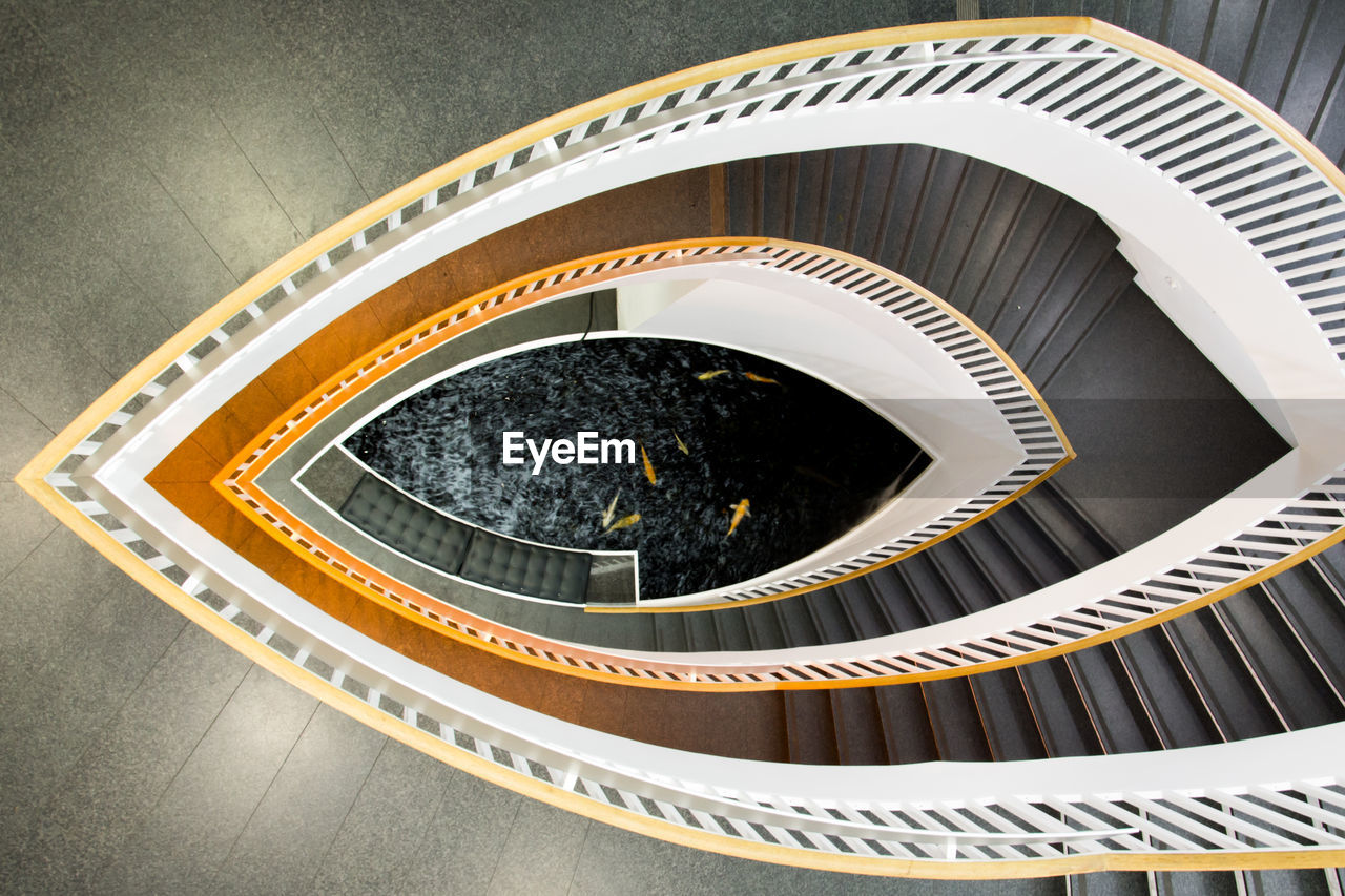 High angle view of spiral staircase leading towards pond