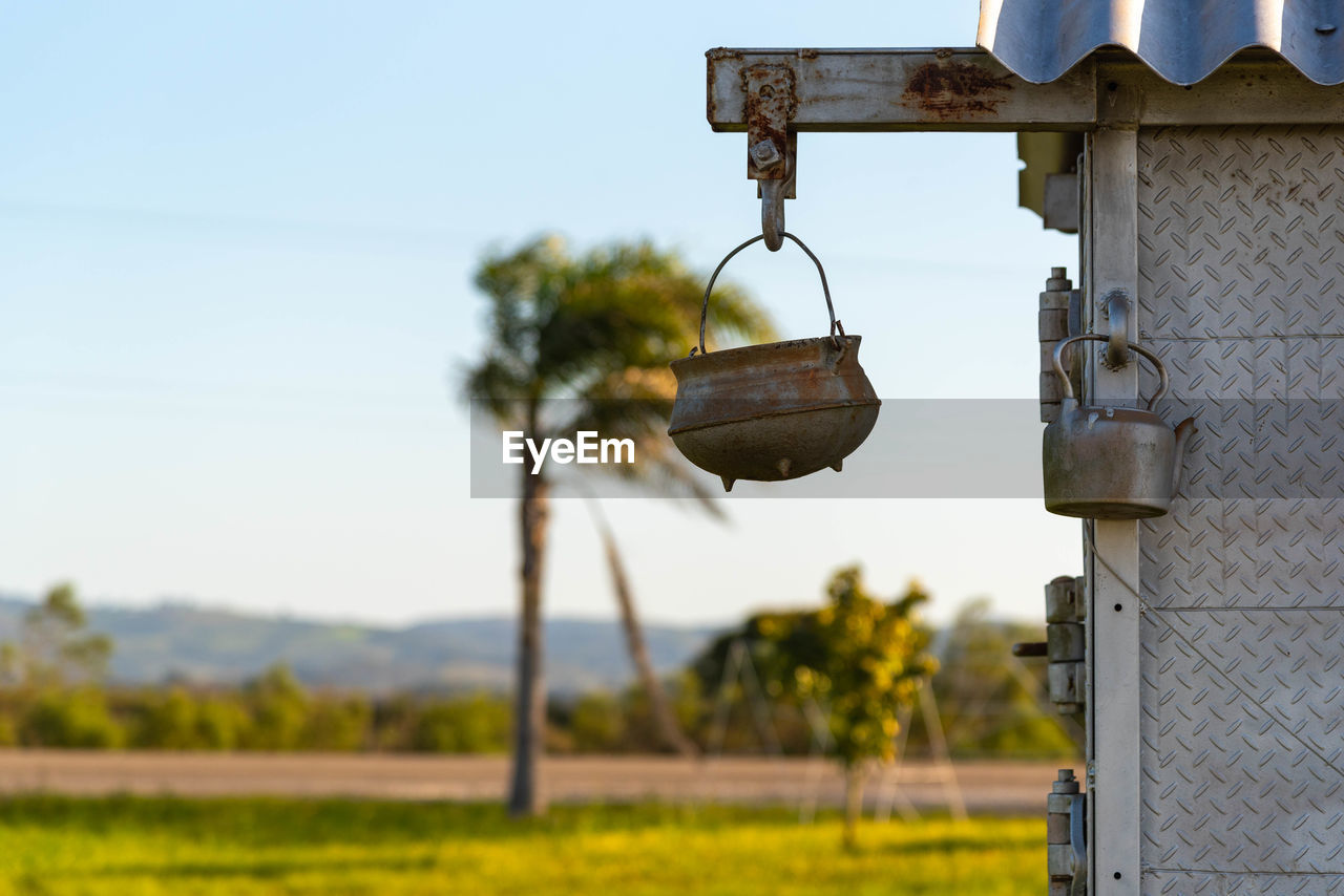 CLOSE-UP OF LIGHT BULB HANGING ON FIELD