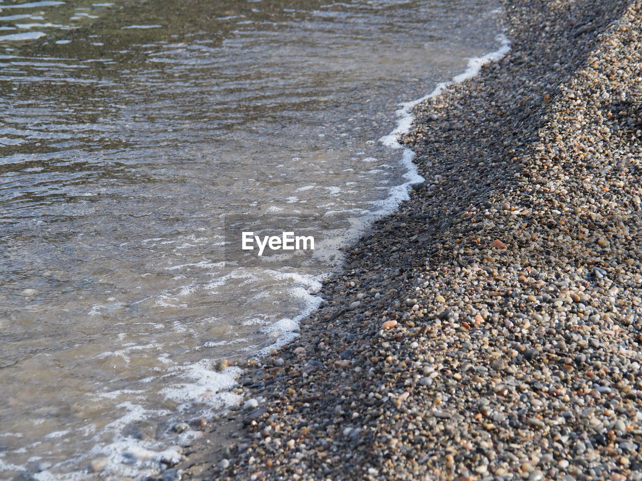 water, beach, land, shore, sand, sea, nature, day, high angle view, wave, no people, motion, beauty in nature, rock, road surface, water sports, asphalt, coast, sports, outdoors, tranquility, body of water, soil, pebble, gravel, scenics - nature, sunlight, wet, stone