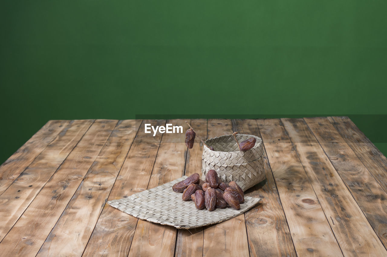 HIGH ANGLE VIEW OF BIRD PERCHING ON TABLE