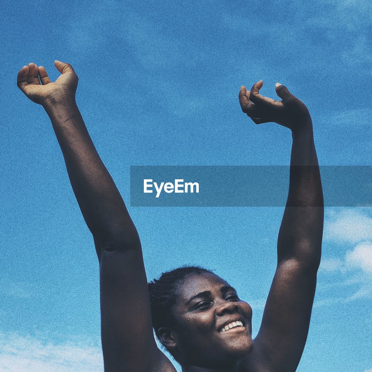 PORTRAIT OF SMILING YOUNG WOMAN AGAINST SKY