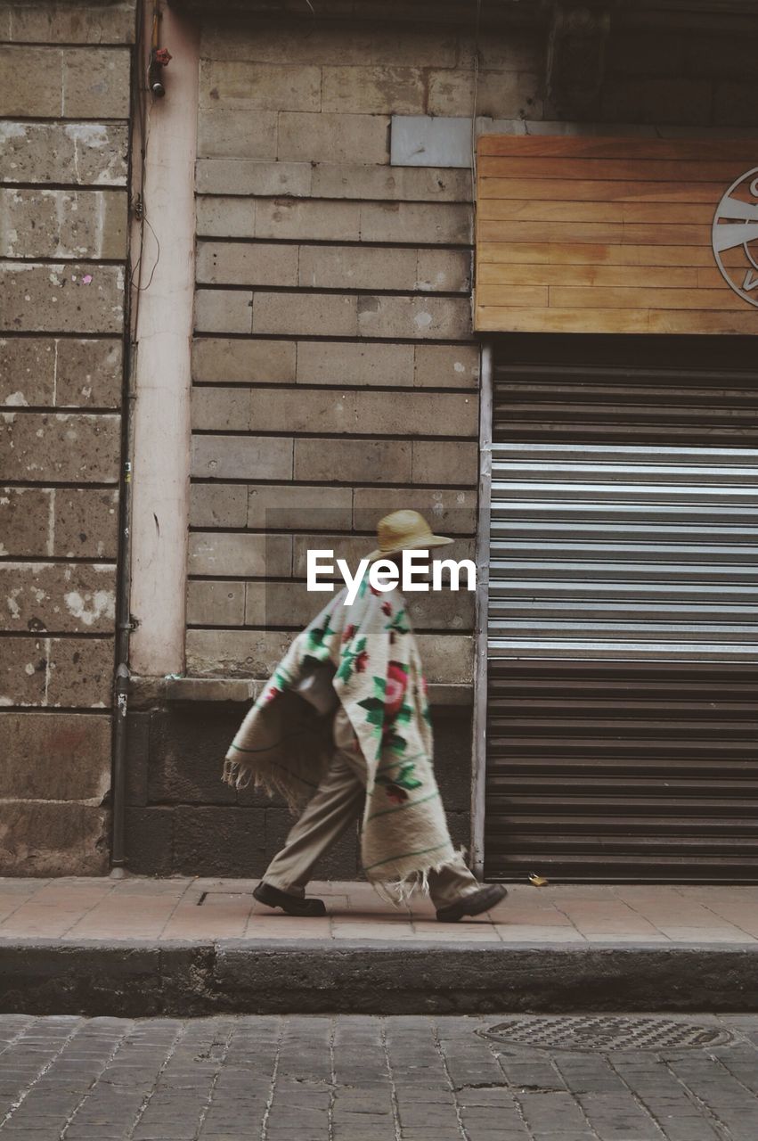 Man walking past shuttered store