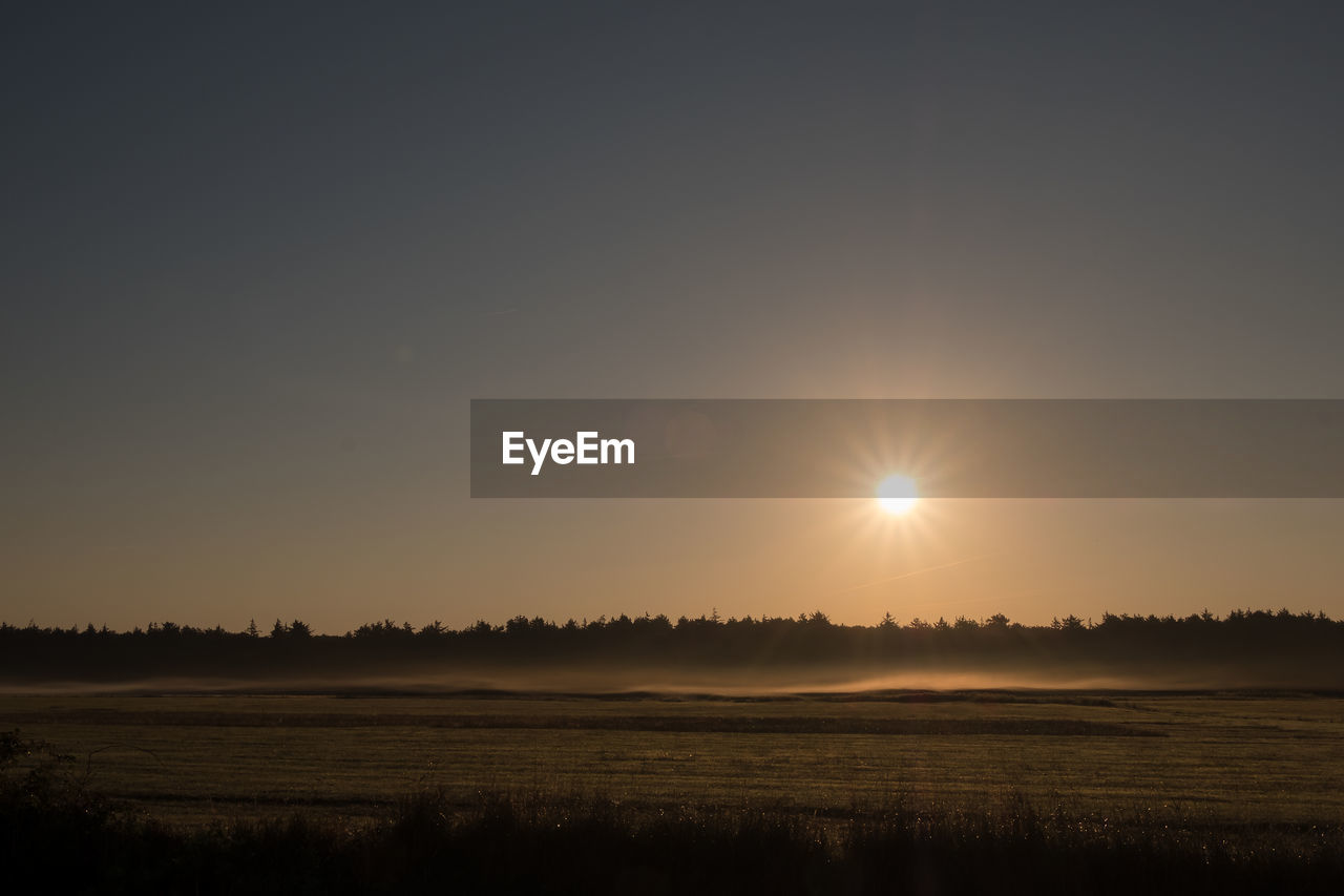 Scenic view of field against sky during sunset