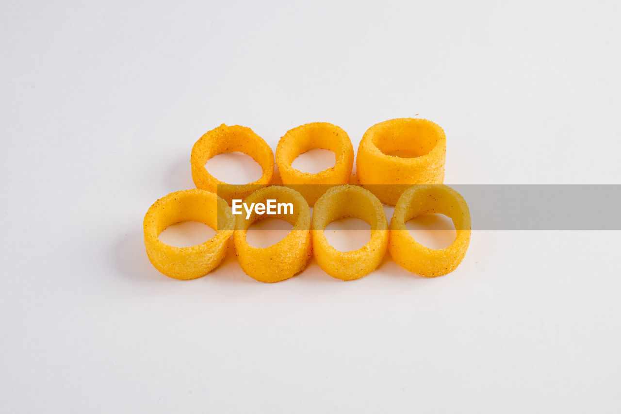 HIGH ANGLE VIEW OF ORANGE EGGS AGAINST WHITE BACKGROUND