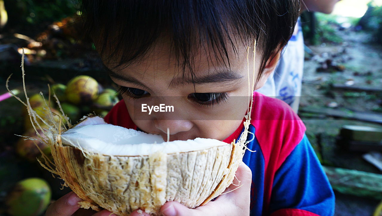 Close-up of boy eating coconut