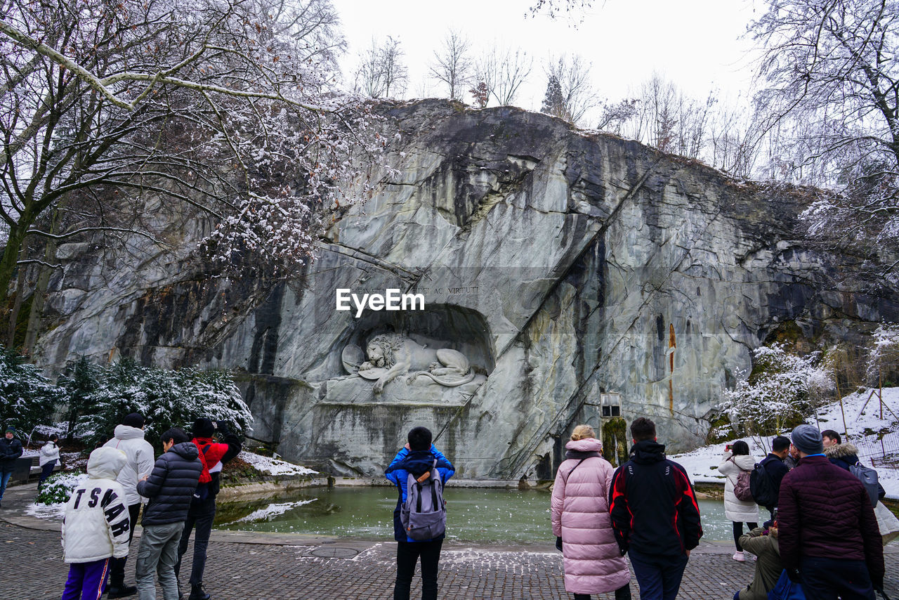 REAR VIEW OF PEOPLE WALKING ON ROCK