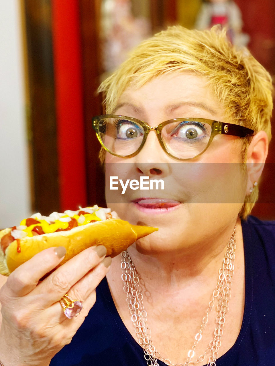 Close-up portrait of woman eating hotdog