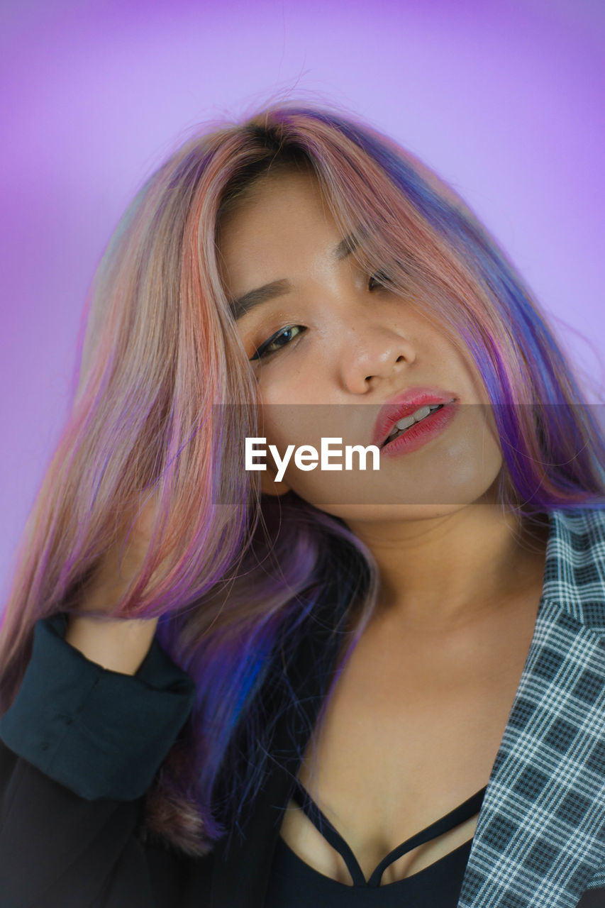 human hair, portrait, one person, women, long hair, hairstyle, blond hair, adult, black hair, young adult, brown hair, purple, blue, headshot, teenager, clothing, human face, colored background, studio shot, pink, looking at camera, indoors, photo shoot, person, front view, fashion, hair color, make-up, female, smiling, human eye, emotion, casual clothing, close-up, lifestyles, looking, pink lipstick, arts culture and entertainment, happiness, portrait photography, waist up, dyed hair