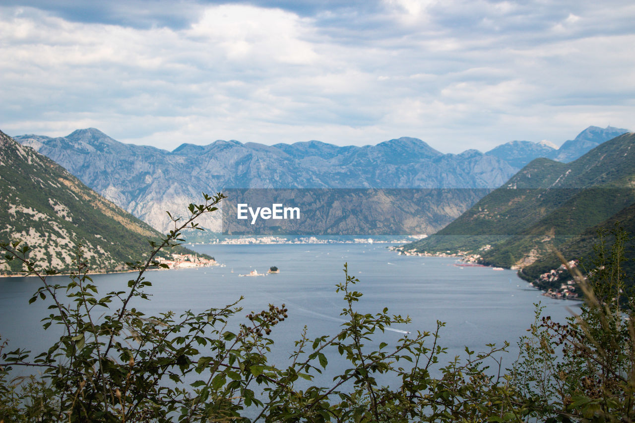 Scenic view of lake by mountains against sky