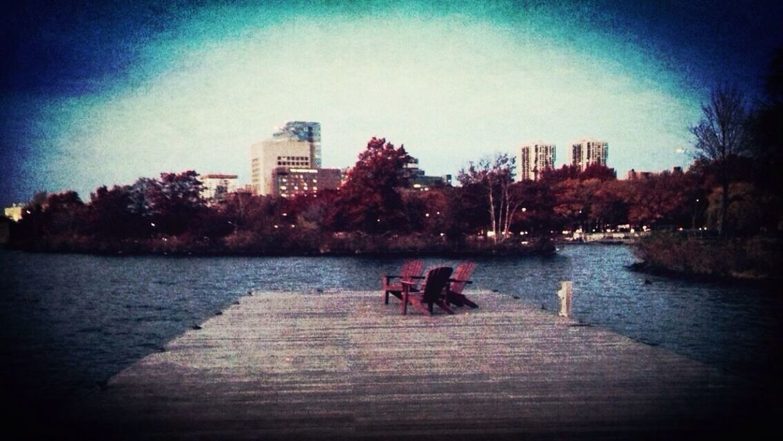 PEOPLE SITTING ON BENCH IN RIVER