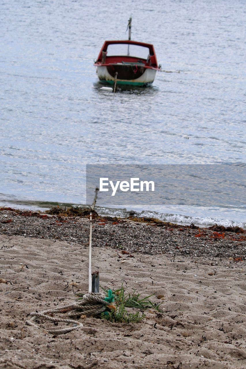 BOAT MOORED ON LAKE SHORE