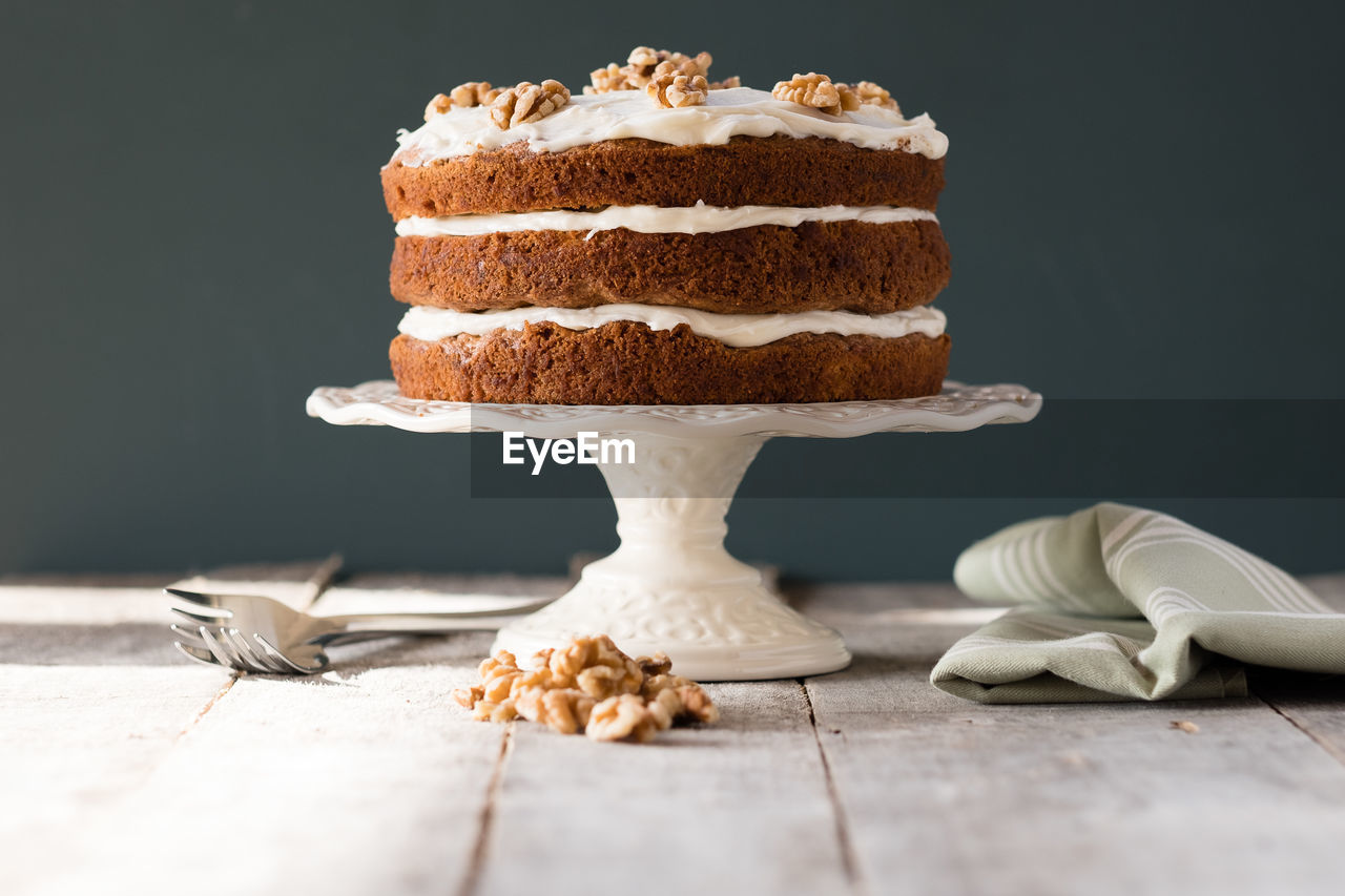 Carrot cake on a cake stand with cream cheese frosting