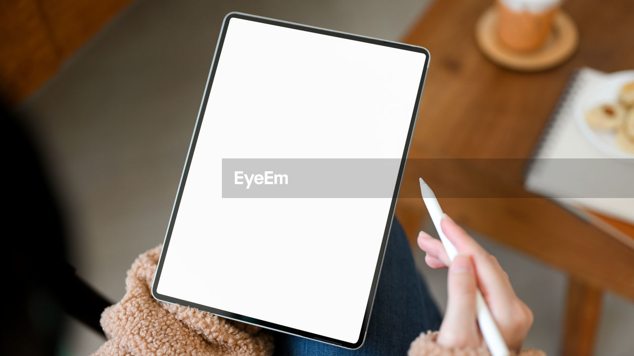 cropped hands of woman using digital tablet