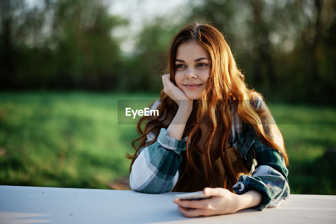 portrait of young woman sitting at park