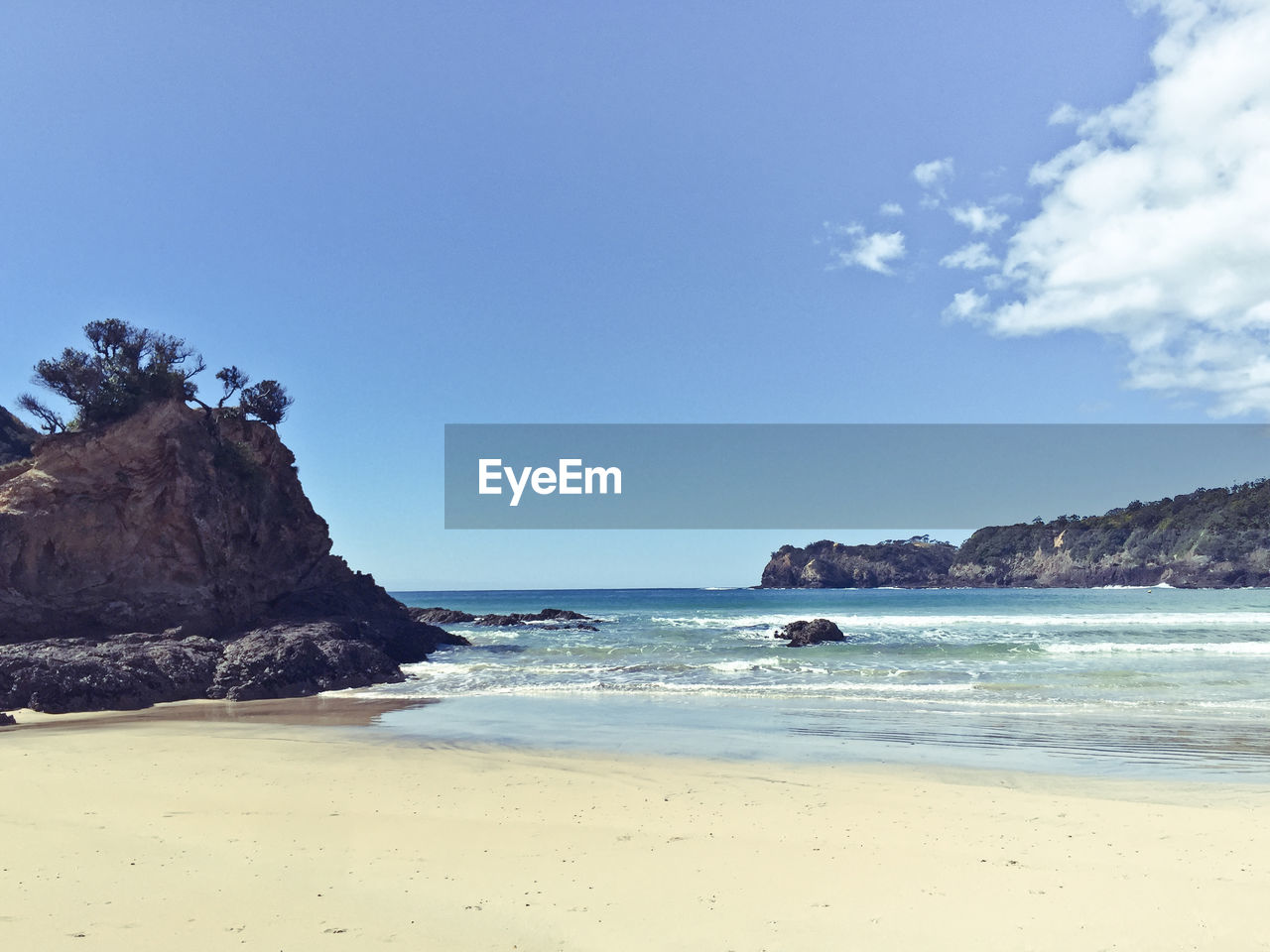 View of calm beach against blue sky