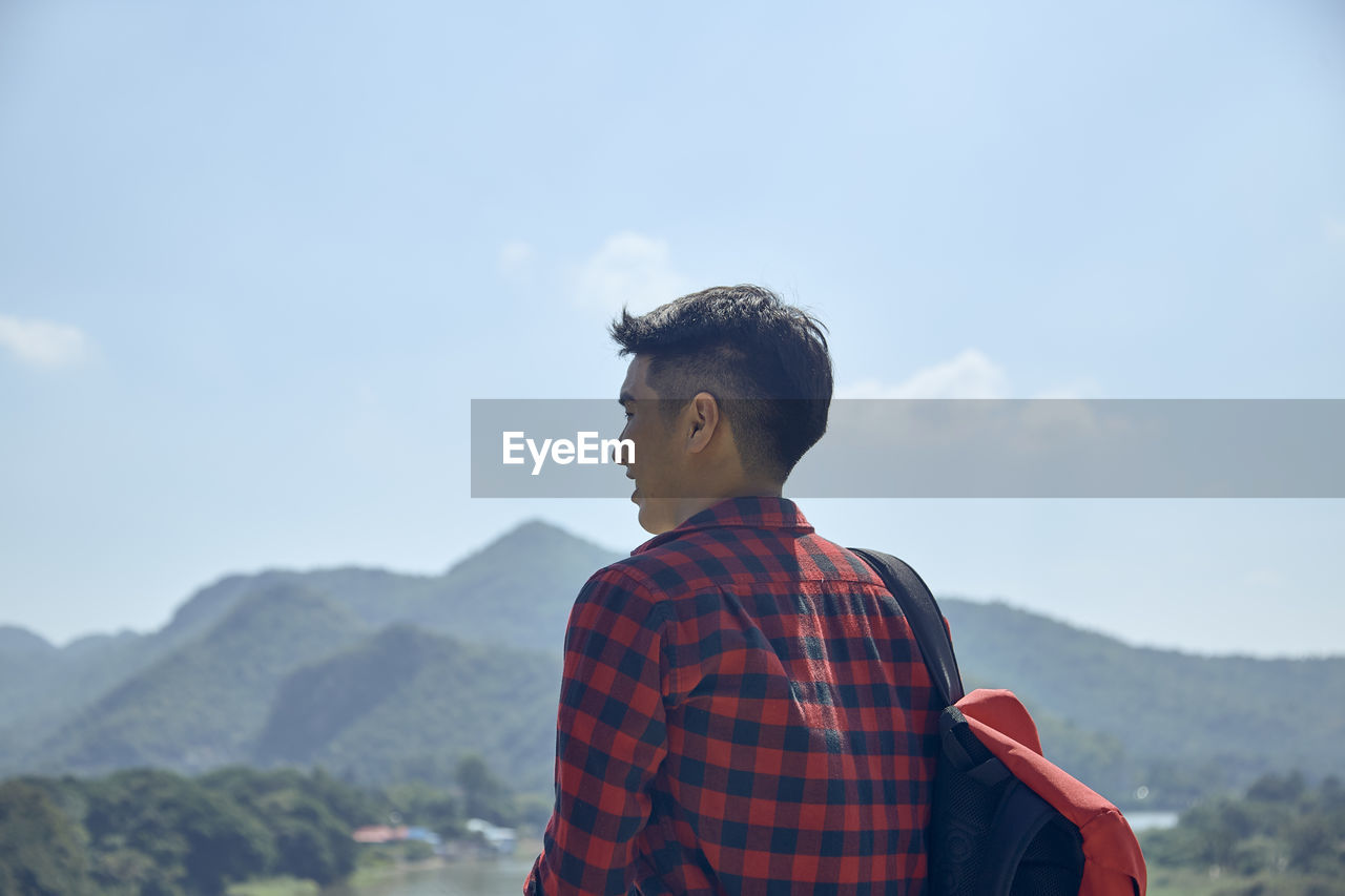 Man looking at mountain against sky