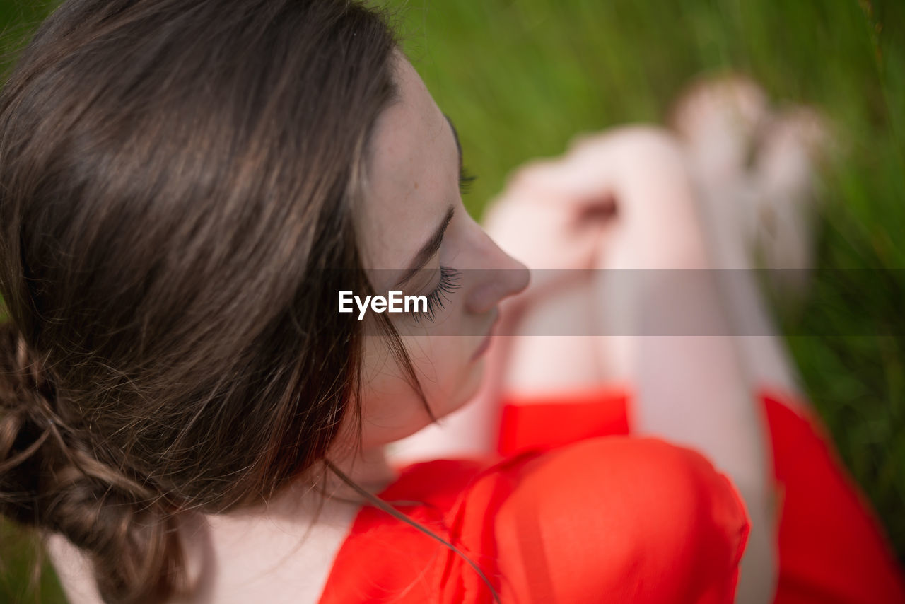 High angle view of young woman sitting outdoors