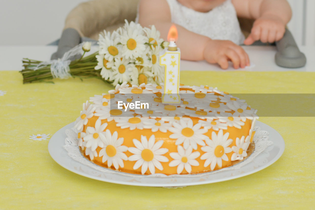 Yellow cake with daisy flowers for baby