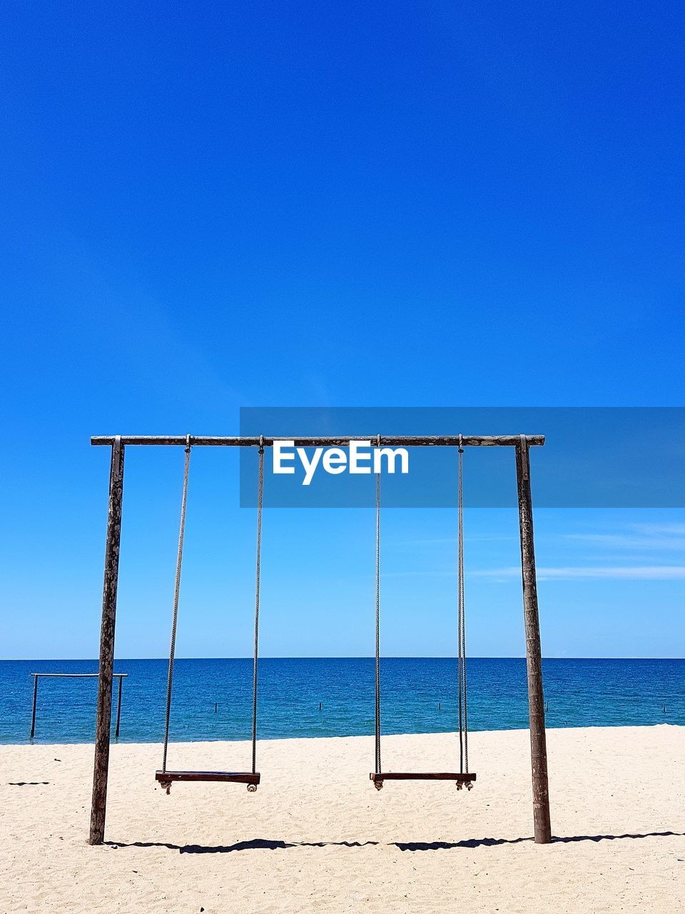 Scenic view of beach against clear blue sky