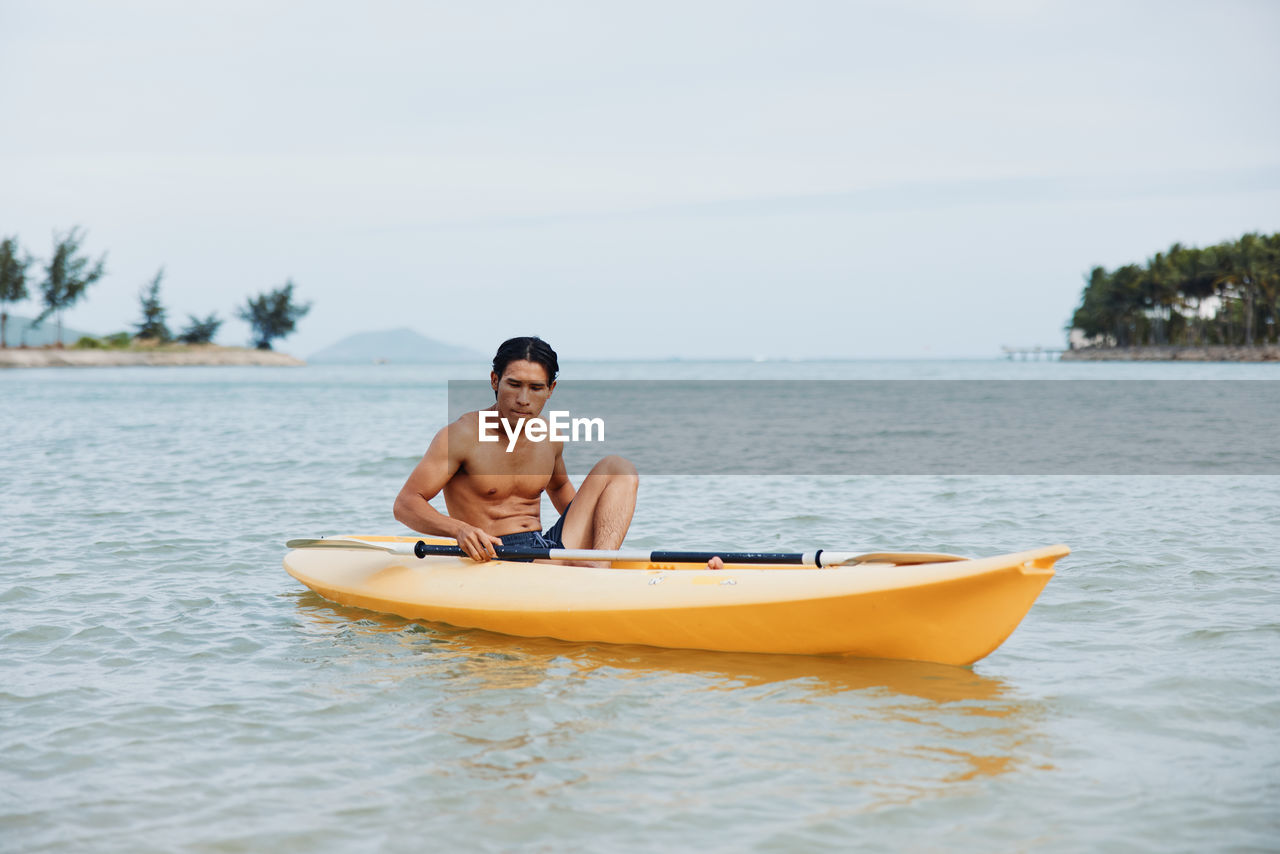 rear view of man kayaking in sea