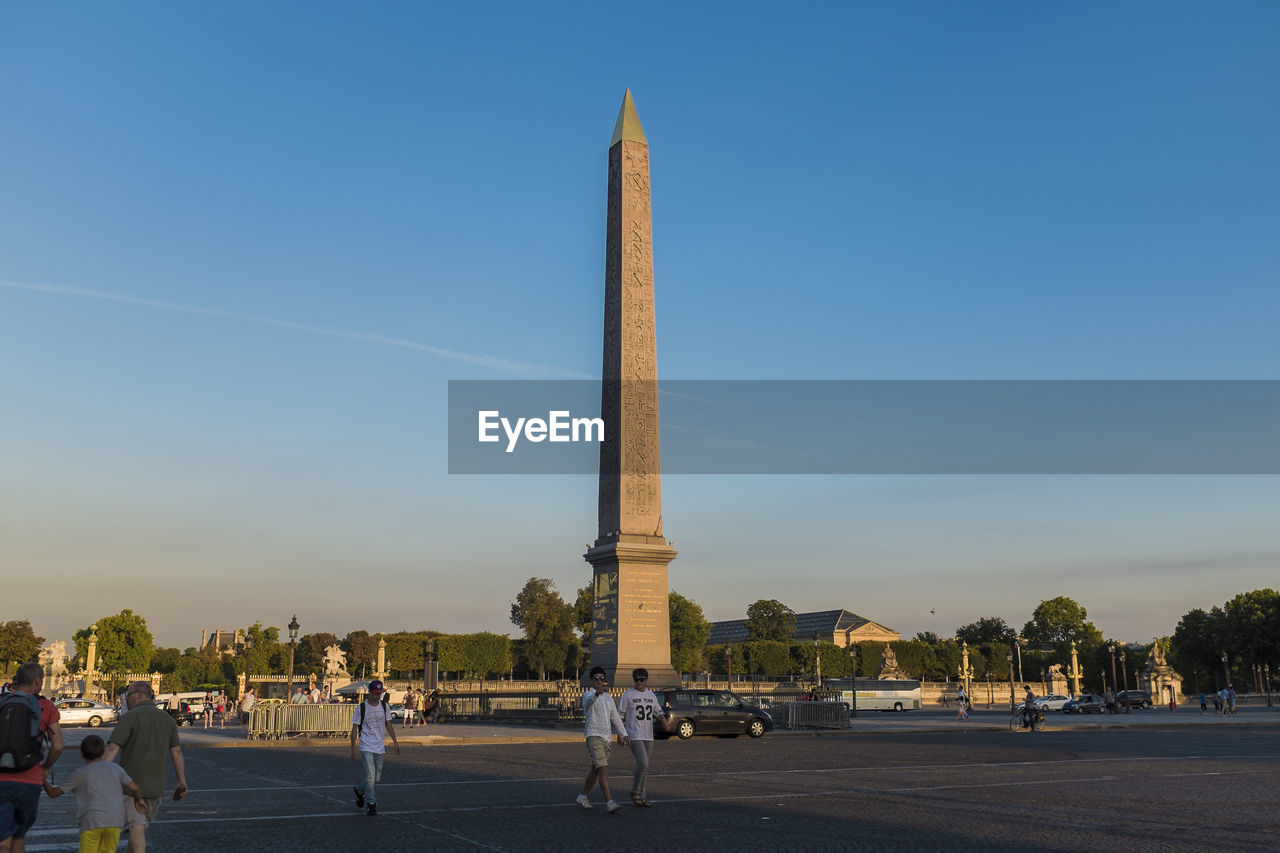 People at luxor obelisk in place de la concorde against sky