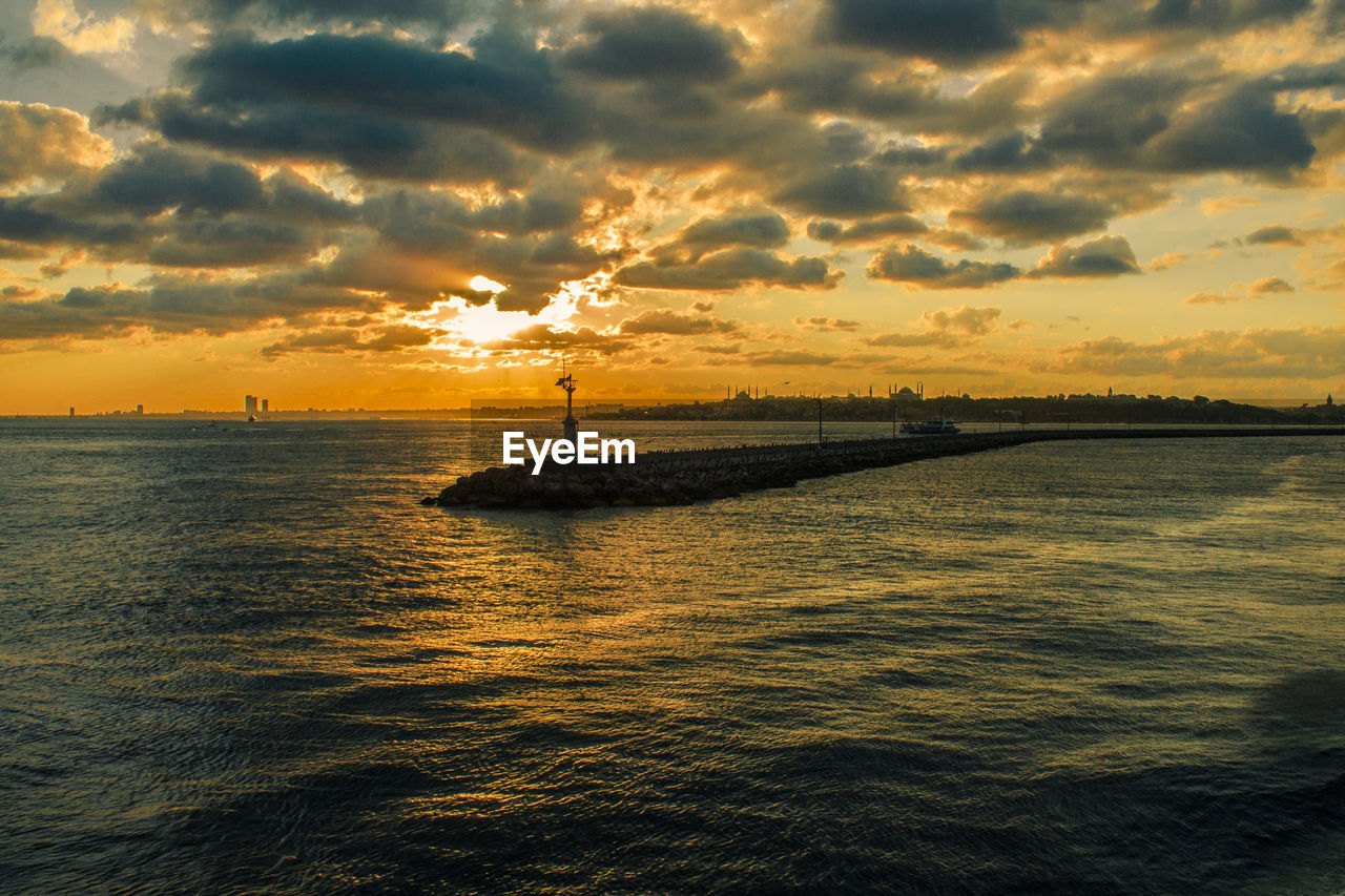 Scenic view of sea with pier during sunset