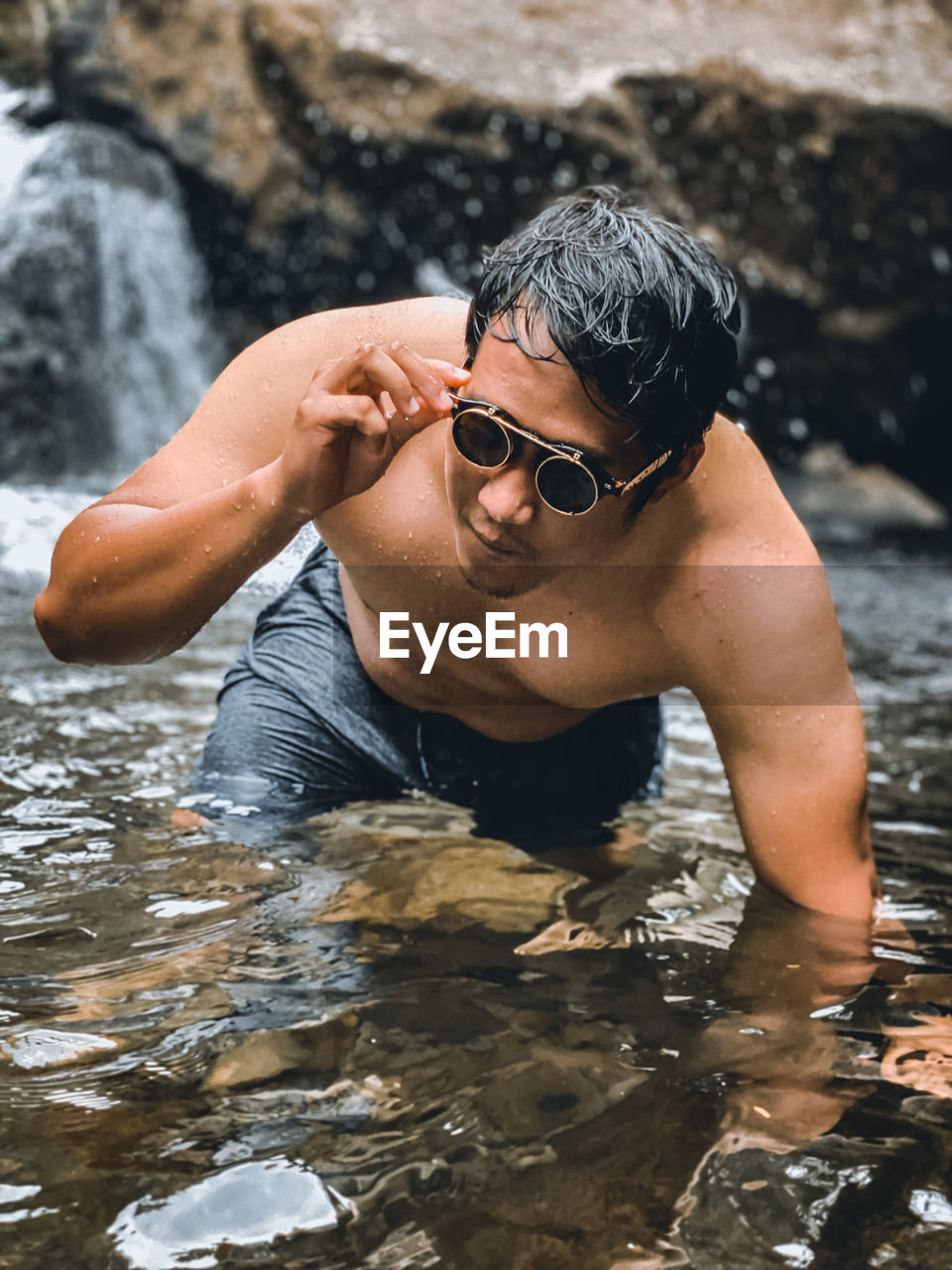 Young man wearing sunglasses on rock