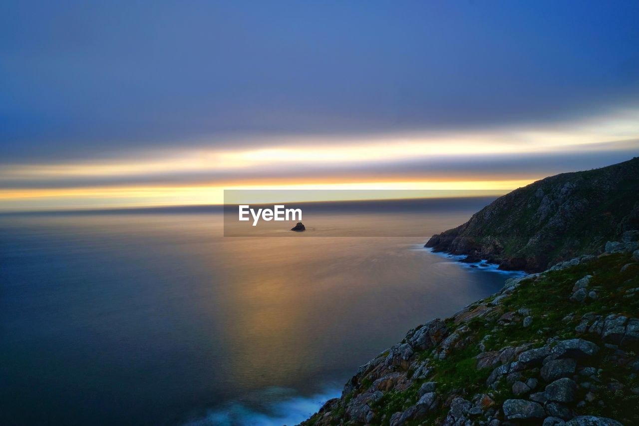 Panoramic view of sunset over ocean horizon from fisterra lighthouse, spain